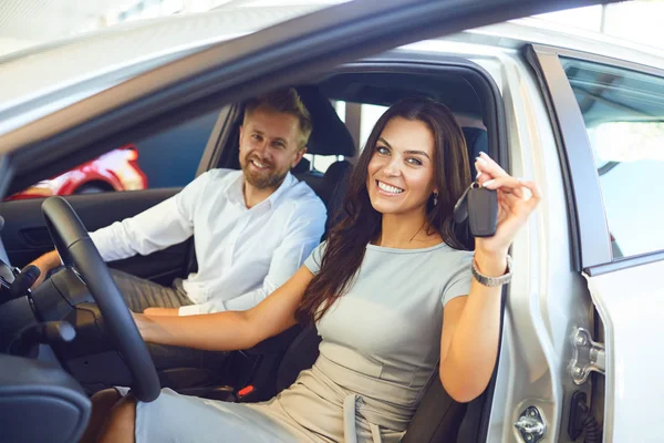 Um casal feliz comprou um carro novo em um showroom do carro . — Fotografia de Stock