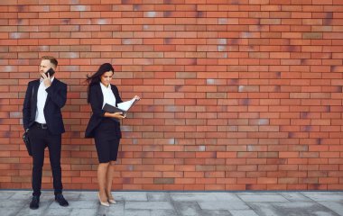 İş adamları tuğla duvar arka plan üzerinde durmak. İş işi profesyonel toplantı kavramı.