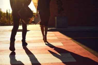 Geri görünüm. İş Adamları şehir caddesi boyunca yürüyor.