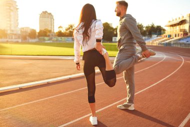 Spor giyimli çift stadyumda ısınma yapıyor