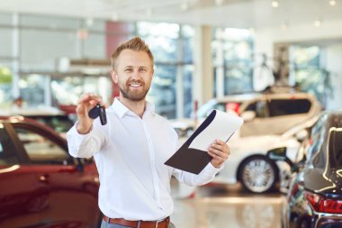 Bir araba satıcısı bir showroom ayakta gülümseyen.