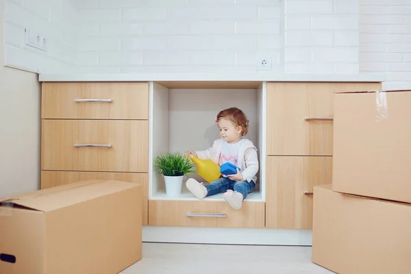 Het kind pakt de dozen in het nieuwe huis uit — Stockfoto