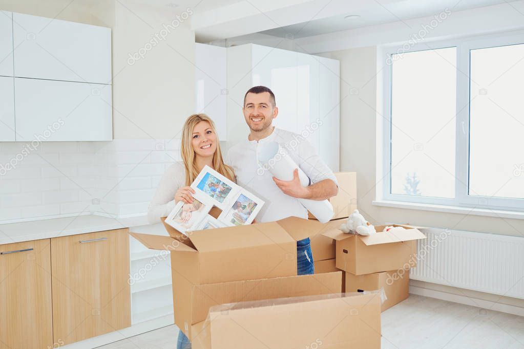 Happy couple unpacking boxes at new house