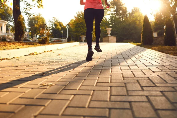 Mężczyzna w odzieży sportowej biegnie rano po drodze.. — Zdjęcie stockowe