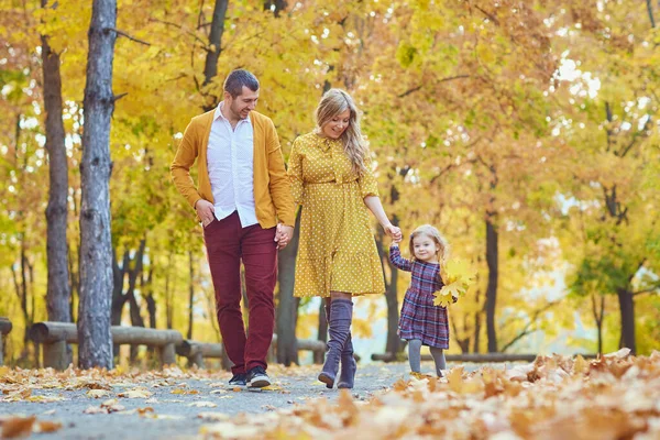 Familjen går i parken i gula hösten. — Stockfoto