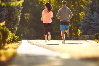 Spor bir çift sabah şehir caddesinde koşuyor..