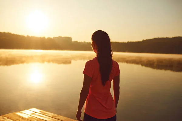 Egy lány meditál reggel a tó ünnepén nyáron ősszel.. — Stock Fotó