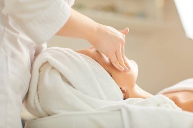 Güzellik uzmanı kıza yüz masajı yapıyor.