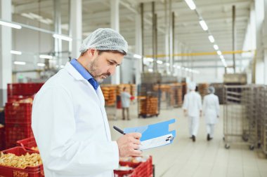 Technologist müfettiş fabrikada kağıtları ile klasöre bir giriş yapar