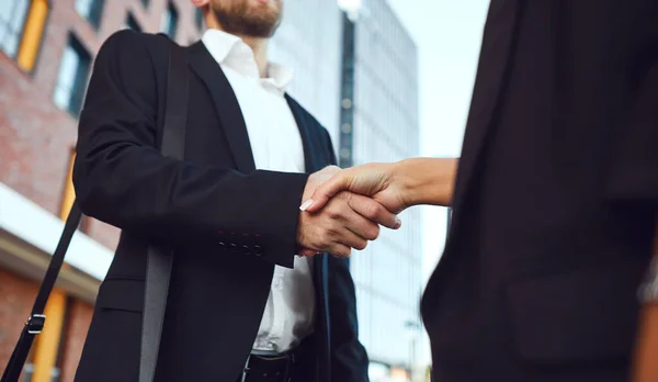 Handshake business. Businessman and business woman make handshakes while standing outdoors