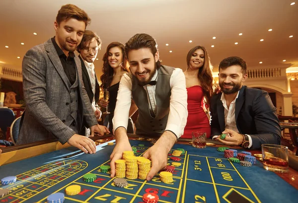 Ευτυχισμένος τύπος που παίζει τυχερά παιχνίδια σε μια ρουλέτα καζίνο — Φωτογραφία Αρχείου
