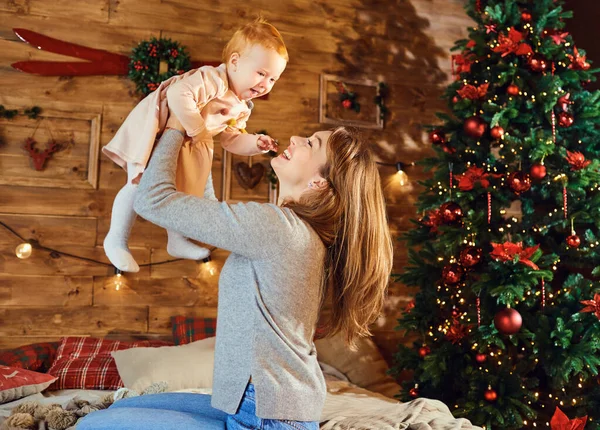 クリスマスの部屋に赤ちゃんを持つ母親. — ストック写真