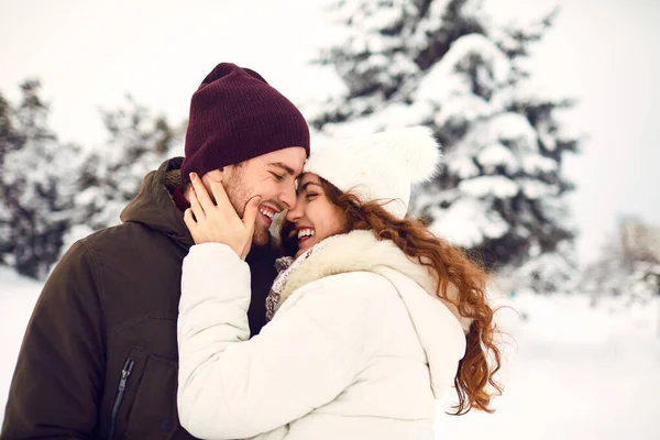 Young couple on the snow in winter in the park — Stock Photo, Image