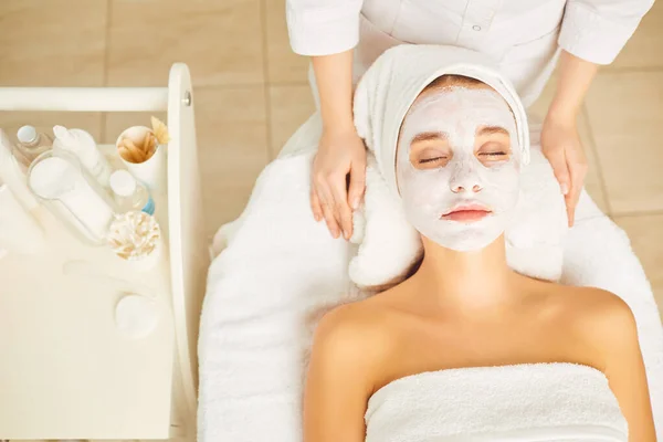 Cosmetic mask on the face of a woman in the spa salon.