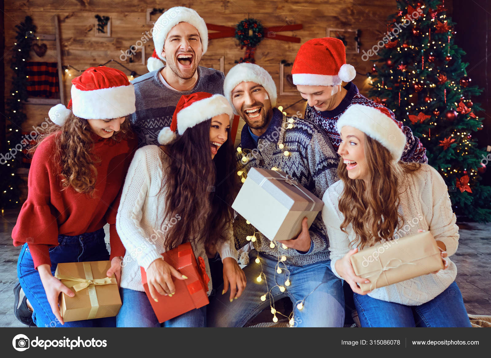 Grupo De Jovens Amigos Alegres Sentados Por Uma Árvore De Natal