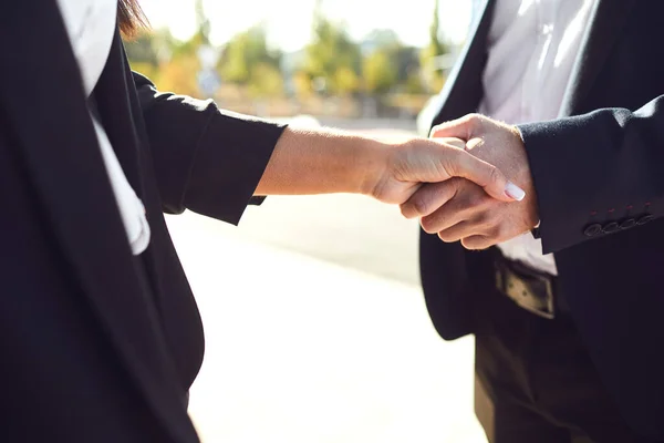 Handshake biznesu. Biznesmen i kobieta biznesu zrobić uściski dłoni stojąc na zewnątrz — Zdjęcie stockowe