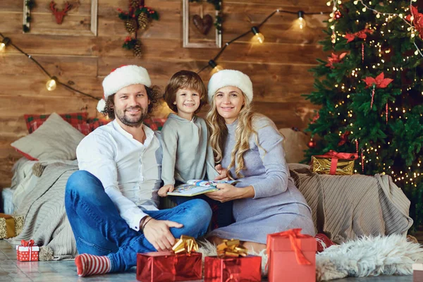 Familie lacht in het huis met een kerstboom — Stockfoto