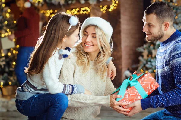De familie geeft cadeaus aan het huis met Kerstmis.. — Stockfoto