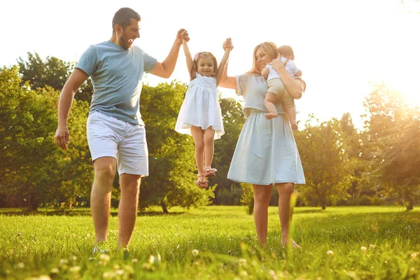 Familjevandring med barn vid solnedgången på naturen — Stockfoto