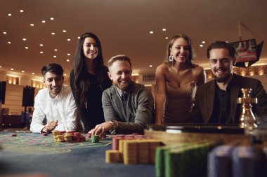 Mutlu insanlar kumarhanede rulet pokerinde kumar oynuyorlar.
