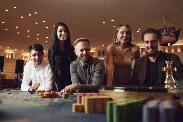 Ευτυχισμένοι άνθρωποι στοιχηματίζουν σε τυχερά παιχνίδια στο πόκερ ρουλέτας σε ένα καζίνο — Φωτογραφία Αρχείου