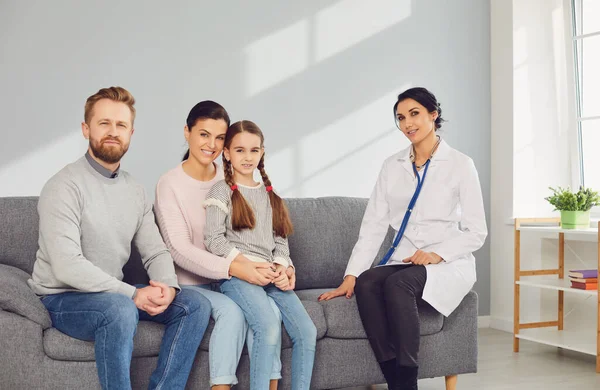 Médico pediatra mulher com família no quarto sentado não no sofá . — Fotografia de Stock