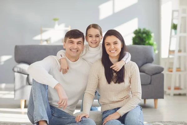 Gelukkig glimlachend gezin. Dochter moeder en vader glimlachend knuffelen vrolijk in een kamer thuis. — Stockfoto