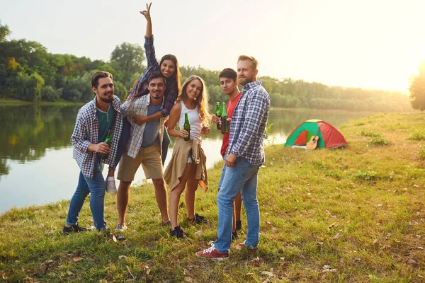Группа людей улыбается стоя на пикнике — стоковое фото