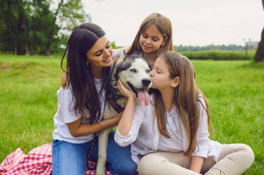 Parkta anneleri ve köpekleri olan iki sevimli kız kardeş. Kırsaldaki evcil hayvanlarıyla mutlu bir aile