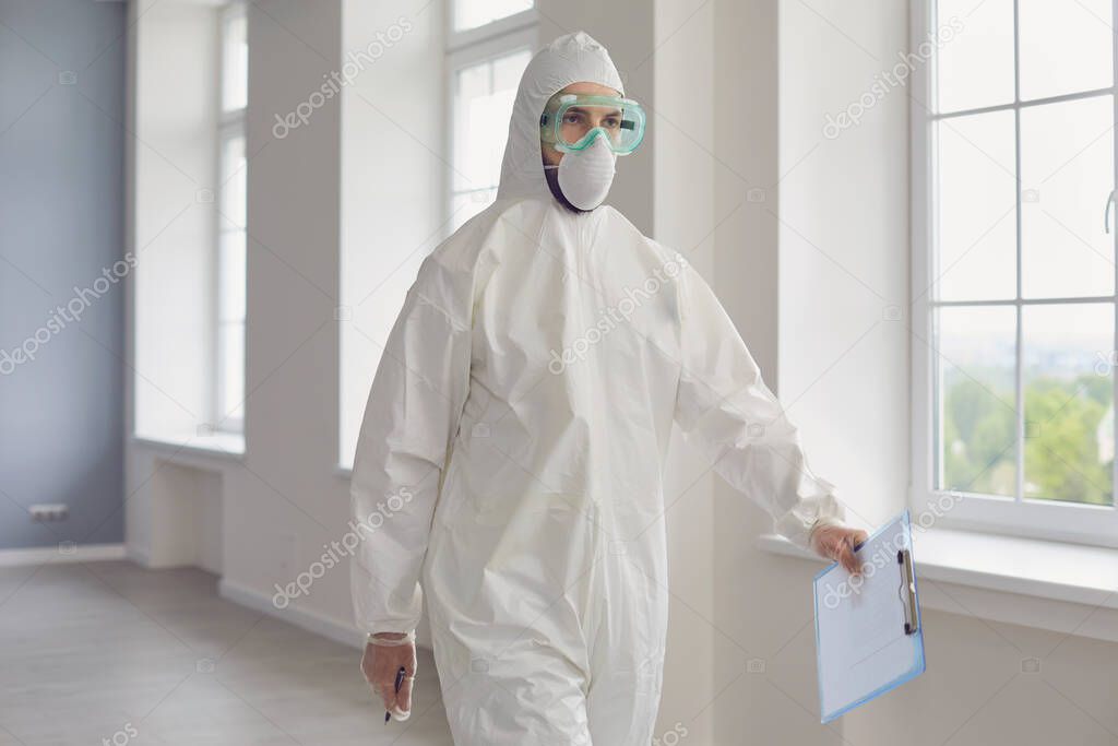 Doctor in protective wear walking along hospital hall. Medic in hazmat suit fighting with contagious disease at clinic