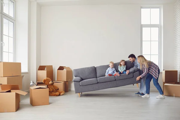 Счастливая семья с детьми переезжает с коробками в новый жилой дом . — стоковое фото