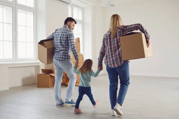 Glad familj med barn flyttar med lådor i ett nytt lägenhetshus. — Stockfoto