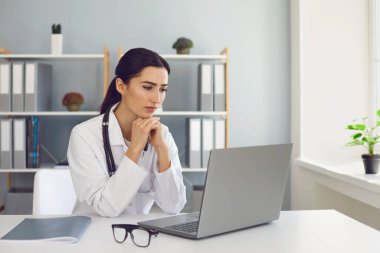 Hastanede dizüstü bilgisayarla hastayla internet üzerinden konuşan bir doktor. Teletıp ve online müşteri danışmanlığı