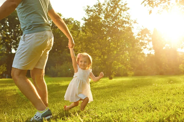 Fathers day. Father plays with his daughter in the summer park. — Stockfoto