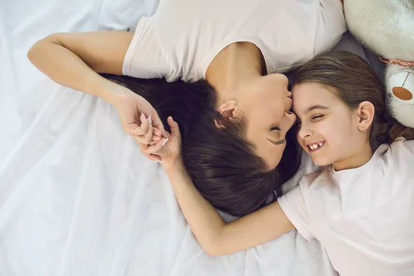 Glücklicher Muttertag. Top-Ansicht. Porträt einer glücklichen Mutter und Tochter, die zu Hause auf dem Bett liegen. — Stockfoto