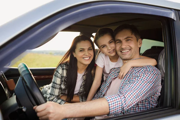 Happy family on the road in a car on an adventure vacation trip.