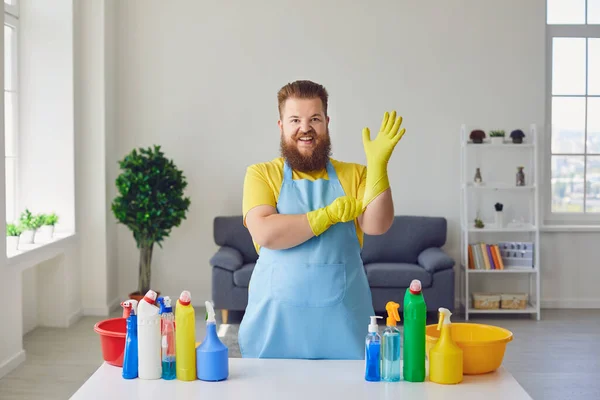 Oda temizlikçisi. Lastik eldivenli neşeli adam evde temizlik malzemeleriyle — Stok fotoğraf