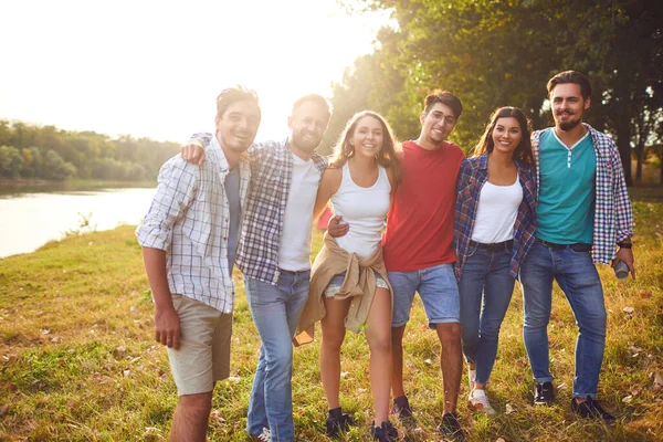 Gruppo di persone sorridenti in piedi su un picnic — Foto Stock