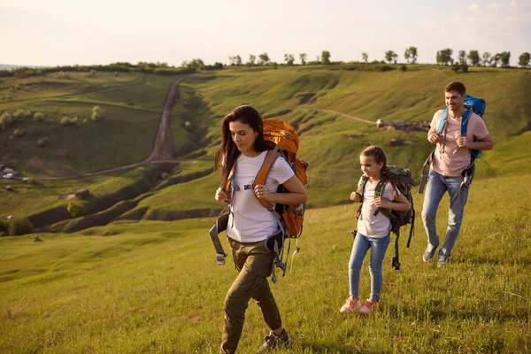 Família de viagem feliz com mochilas está andando na natureza. Acampar na natureza . — Fotografia de Stock