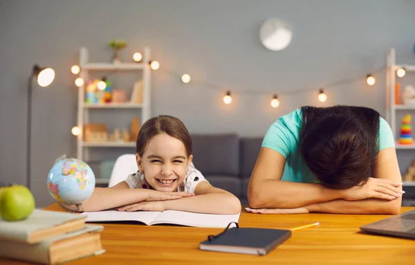 Trabalho de estresse com crianças em casa. Cansada mãe dormindo em um desktop filha impertinente sorrindo olhando para a câmera em casa escritório . — Fotografia de Stock