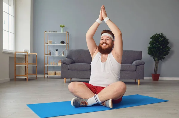 Dicker Mann meditiert in Lotusposition und sitzt zu Hause auf dem Boden — Stockfoto
