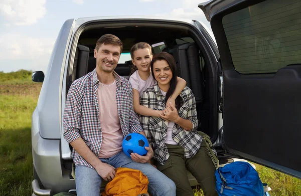 Счастливая семья туристов с рюкзаками на фоне автомобиля на природе . — стоковое фото