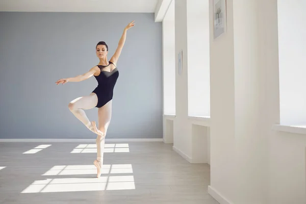 Μπαλαρίνα. Νεαρή χορεύτρια μπαλέτου κάνει πρόβα σε ένα λευκό στούντιο με παράθυρα.. — Φωτογραφία Αρχείου