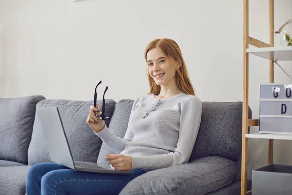 Online business. Smiling young girl with glasses working on project through web from home. Student watching webinar — Stock Photo, Image