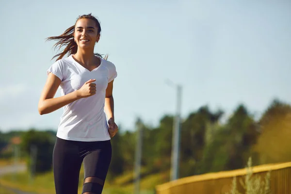 Chica corredor corre a lo largo de la carretera — Foto de Stock