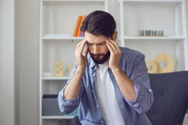 Evde baş ağrısı ve yüksek tansiyonu olan genç bir adam var..