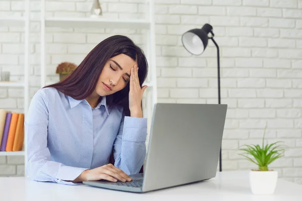 Överarbetad och trött affärskvinna arbetar på bärbar dator i hemmakontoret. Student gör sig redo för online-test — Stockfoto