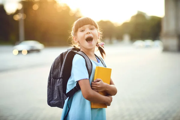 Bonne petite écolière avec un sac à dos sur le chemin de l'école. — Photo