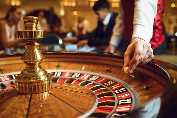 Hand eines Croupier mit einer Kugel auf einem Rouletterad während eines Spiels im Casino. — Stockfoto