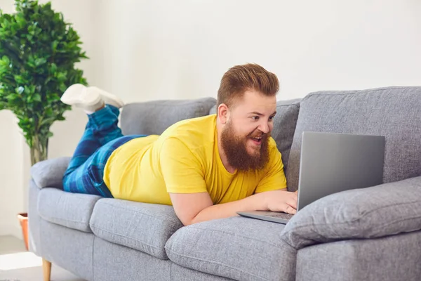 Funny fat man working online shopping shrpping watching a video at home in the room.